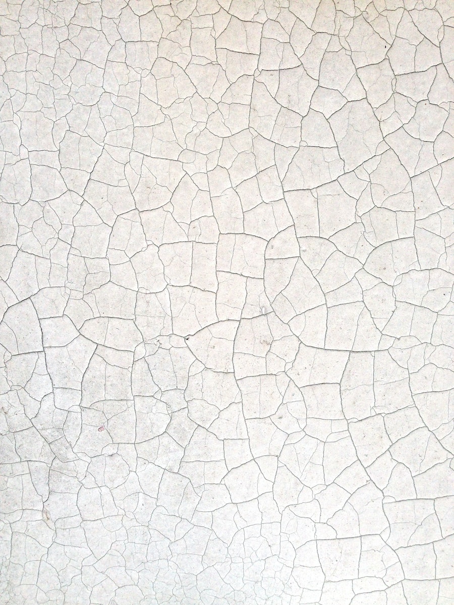 a close up of a white wall with cracks in it